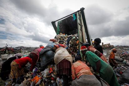 Varias mujeres buscan objetos de valor entre los residuos de un contenedor en un vertedero de Nairobi (Kenia).