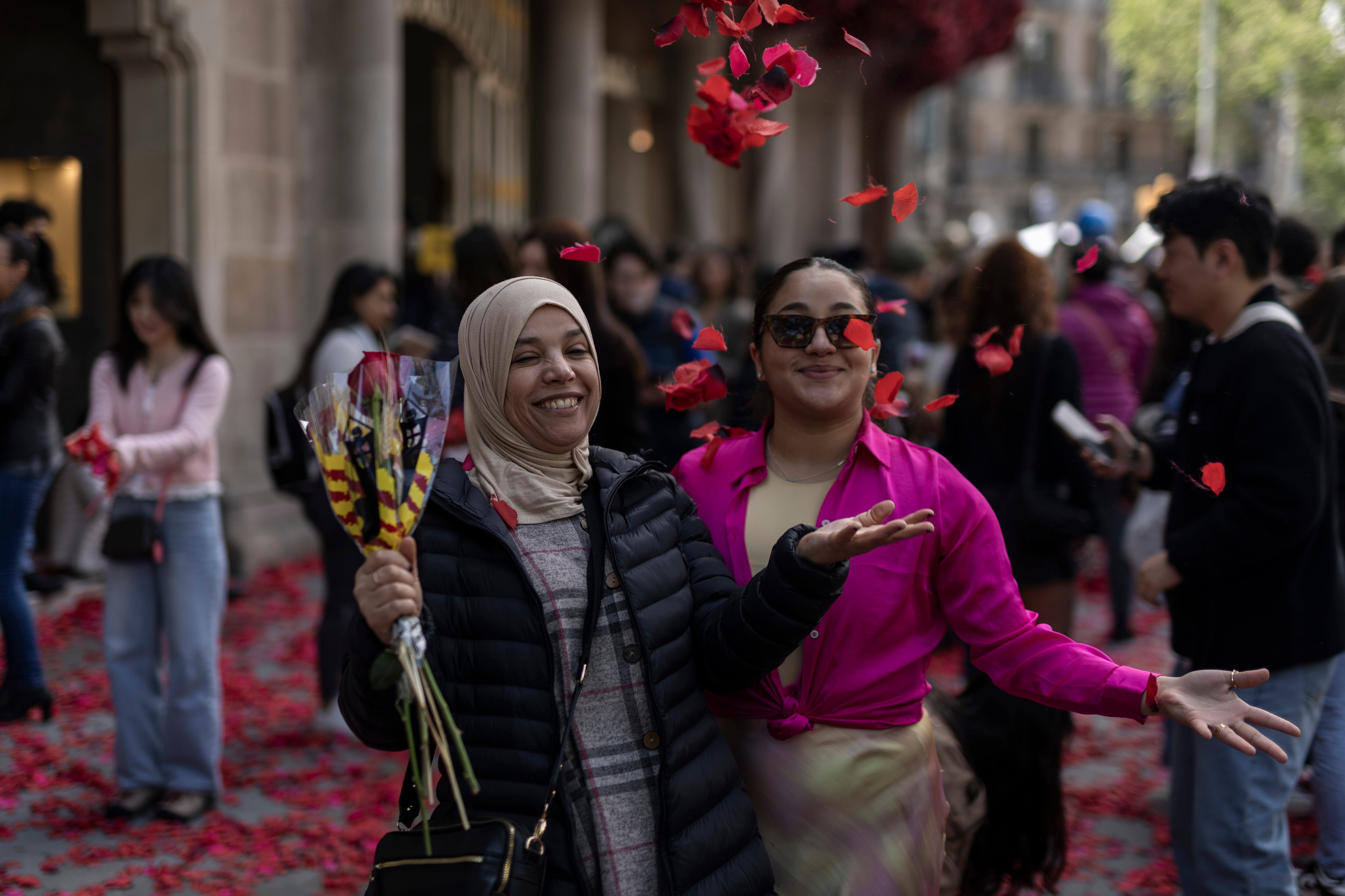 Dos mujeres tiran al aire pétalos de rosa frente a la Casa Batlló, este lunes en Barcelona.