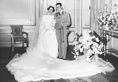 La reina Fabiola de Bélgica, con vestido de novia confeccionado por Balenciaga, posando junto a su esposo Balduino en el Palacio Real de Bruselas antes de su boda.