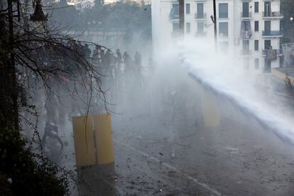 La policía trata de dispersar a los manifestantes con mangueras de agua.