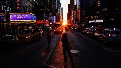 El sol se esconde tras los edificios ante la mirada de los transeúntes que intentan fotografiar el peculiar atardecer.