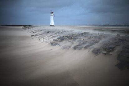 Golpes de viento inusualmente fuertes en el dique junto al faro de Perch Rock en New Brighton. 