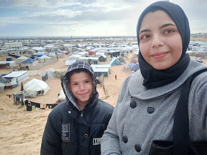 La periodista gazatí Eman Alhaj Ali posa con su hermano, Yusef, en Rafah, junto al campamento de desplazados en el que tuvieron que refugiarse en enero de 2024.