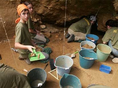 Los estudiantes que colaboran con Aranzadi, ayer, en la excavación del yacimiento arqueológico de Lezetxiki, en Mondragón.