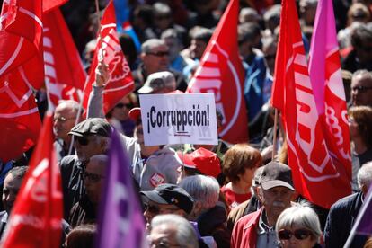 Un hombre porta un carte con la palabra "¡Corruppcion!", en la manifestación del 1 de Mayo en Madrid.