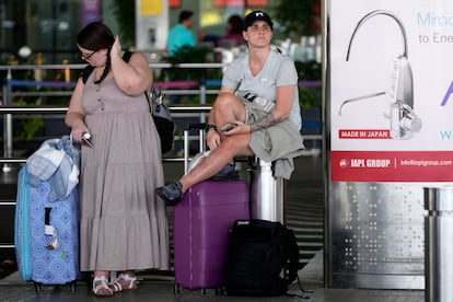 Los viajeros Lauren Clark, a la izquierda, y Shahin Jade Ali esperan en el Aeropuerto Internacional Chhatrapati Shivaji Maharaj (Mumbai, India) a la reapertura del aeropuerto de Heathrow para tomar su vuelo de regreso a la capital británica. 