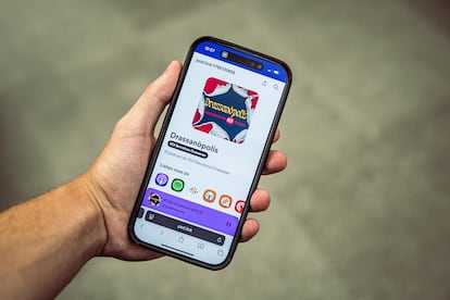 Un hombre escucha el podcast 'Drassanópolis' de la EOI Drassanes desde su dispositivo móvil.