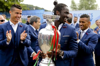 El jugador de la selección portuguesa Eder (c) sujeta el trofeo de campeones de la Eurocopa 2016 junto a Cristiano Ronaldo (i) y Nani (d), durante la celebración del título.