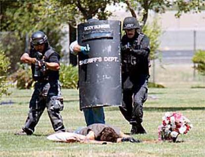 Policías de San Joaquín, California, se aproximan al cadáver de Roger Johnson, junto a la tumba de su esposa.