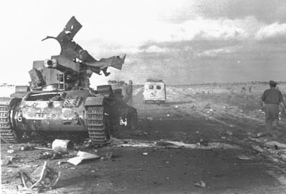 En esta imagen, del 8 de junio de 1967, un vehículo del Ejército judío avanza hacia el frente sirio-israelí pasando al lado de un tanque sirio que ha quedado fuera de combate.