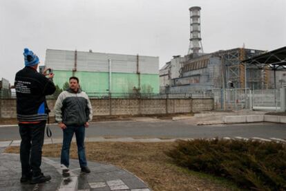 Turistas se hacen fotos frente a los restos del reactor número 4 de Chernobil.