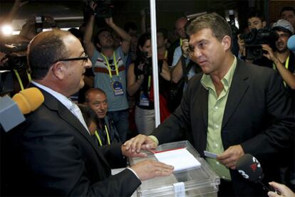 Joan Laporta dialoga con un representante de la mesa electoral antes de depositar su voto.