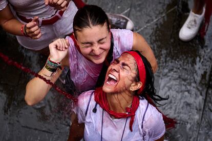 Jóvenes celebran el chupinazo por las calles de Pamplona, este jueves.  
