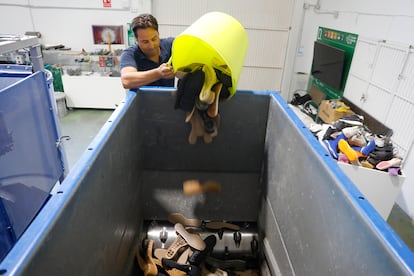 Vicente Rocamora, técnico de sostenibilidad de la planta de reciclaje de calzado de Inescop, en Elda, deposita suelas de zapatos en la trituradora.