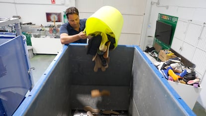 Vicente Rocamora, técnico de sostenibilidad de la planta de reciclaje de calzado de Inescop, en Elda, deposita suelas de zapatos en la trituradora.