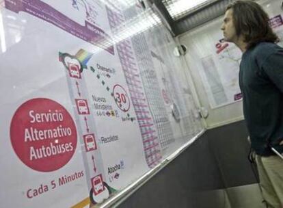 Un usuario consulta un panel informativo de los cortes de Cercanías en la estación de Atocha.