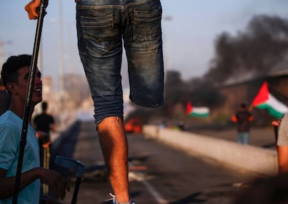 Un manifestante palestino se sostiene con un bastón encima de una barricada durante los enfrentamientos con las fuerzas irlaelíes en el norte de Gaza, el 26 de septiembre de 2018.