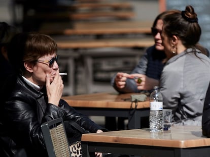 Una mujer fumando en una terraza de Barcelona.