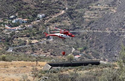 Según estimaciones de la Dirección de Extinción insular, las llamas avanzan hacia la cuenca de Tejeda y el pinar de Tamadaba, ambos pulmones de la isla ricos en vegetación. En la imagen, tomada este domingo, un helicóptero carga agua en un estanque cerca del pueblo de Tejeda.