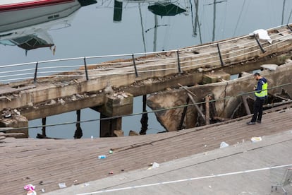 Un agente investiga el hundimiento de una estructura en el puerto de Vigo, Galicia.