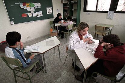 Dos profesoras utilizan pictogramas para enseñar conceptos a niños autistas en el colegio Leo Kanner de Madrid.