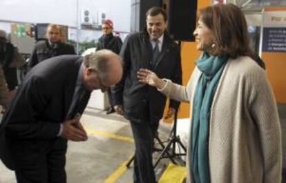 El presidente de Repsol, Antonio Brufau (i), se disculpa ante la alcaldesa de Madrid, Ana Botella (d), por llegar tarde al acto en el que han firmado un convenio para promover el uso de vehículos propulsados con autogás.