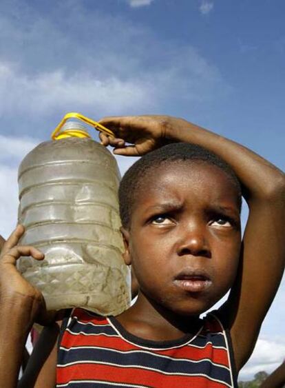 Un niño acarrea agua de un pozo desprotegido, del que se sabe que ha sido fuente de contagio de cólera, en Harare. La falta de suministro en las ciudades fuerza a la población a recurrir a fuentes de agua insálubres