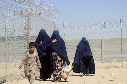 Mujeres y niños afganos, junto a la valla que separa la frontera entre Pakistán y Afganistán en la localidad paquistaní de Chaman, este sábado.