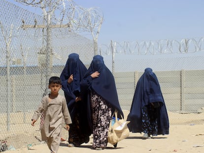 Mujeres y niños afganos, junto a la valla que separa la frontera entre Pakistán y Afganistán en la localidad paquistaní de Chaman, este sábado.