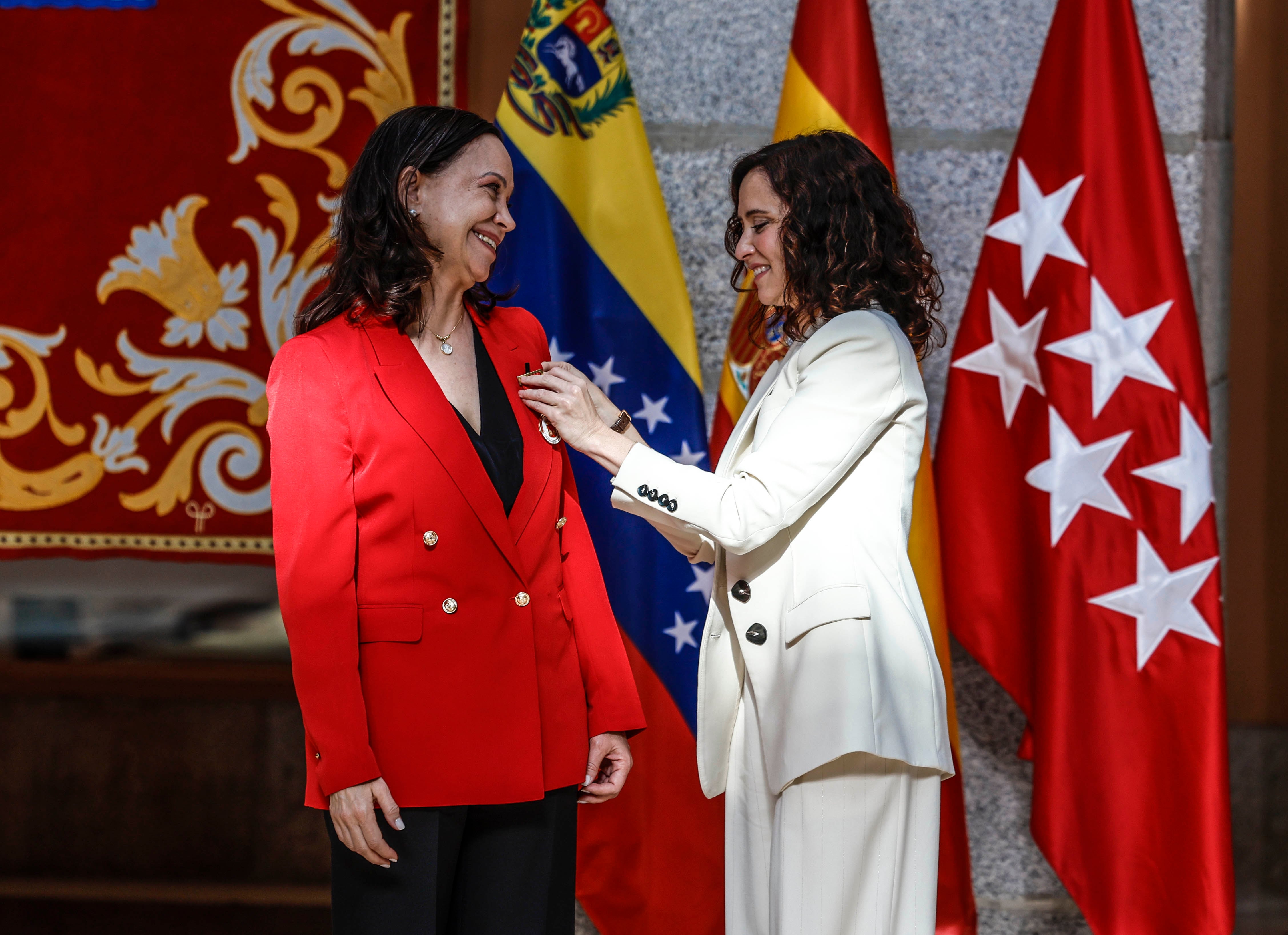 La presidenta de la Comunidad de Madrid, Isabel Díaz Ayuso, entrega la medalla a María Corina Machado.