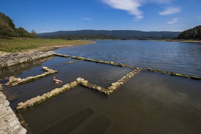 Un niño se sumerge en las ruinas con agua termal de la antigua casa de baños sepultada por el embalse en 1948.