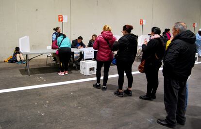 Una cola de votantes frente a la urna en el centro electoral para ciudadanos ecuatorianos en Madrid.