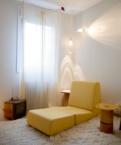 Detalle de la salita junto al dormitorio. En el suelo, la televisión portátil hecha con materiales reciclados Jim Nature, diseño de Philippe Starck para Saba, un regalo de la comisaria Ana Domínguez Siemens. Las lámparas que se proyectan en la paredes son una de sus creaciones.