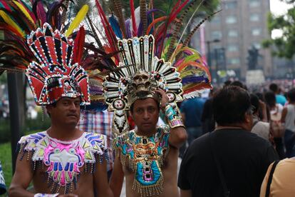 Dos manifestantes ataviados con coronas aztecas