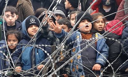 Niños migrantes ante el alambre de espino de la frontera entre Polonia y Bielorrusia, el 11 de noviembre.