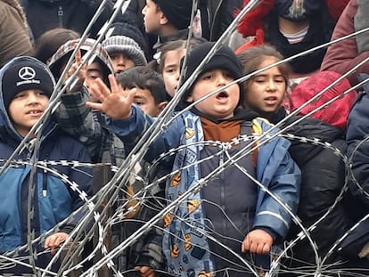 Niños migrantes ante el alambre de espino de la frontera entre Polonia y Bielorrusia, el 11 de noviembre.