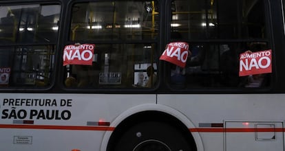 Passageiros de um ônibus que circulava próximo à manifestação seguram cartazes contra o aumento da tarifa.