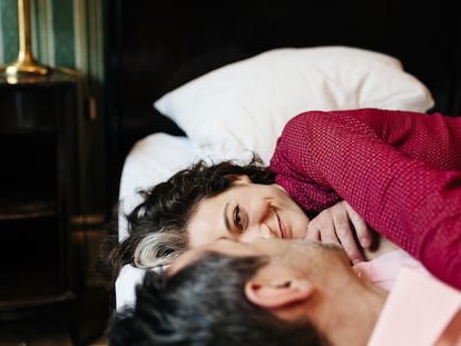 Una pareja tumbada en la cama, posiblemente compartiendo intimidades.