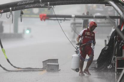 Un mecánico del equipo Ferrari trabaja bajo la tormenta en la clasificación del Gran Premio de Malasia