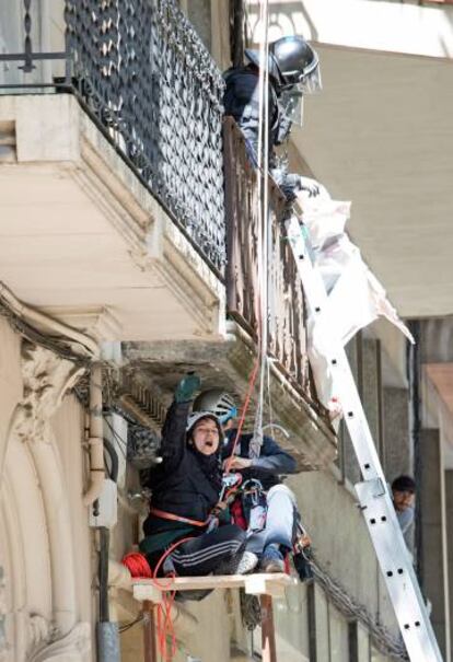 Los Mossos descuelgan a una de las mujeres del edificio okupado.