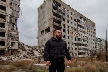 Olexander Billeris, vicedirettore dell'ufficio amministrativo militare di Orijiv, si trova di fronte ai resti di un condominio bombardato.