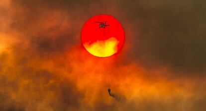 Un helicóptero contra incendios trabaja en la zona cercana a Redding (California), el 27 de julio de 2018.