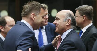 El ministro de Economía en funciones, Luis de Guindos (d), conversa con el ministro eslovaco de Finanzas, Peter Kazimir.