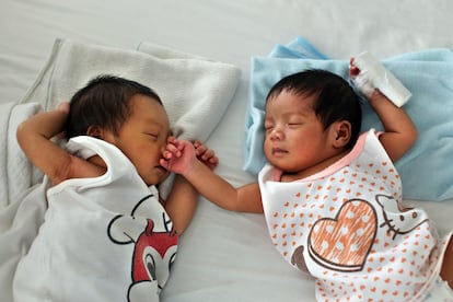 Dos bebés duermen en una cama en la llamada 'fábrica de bebés' de Manila.