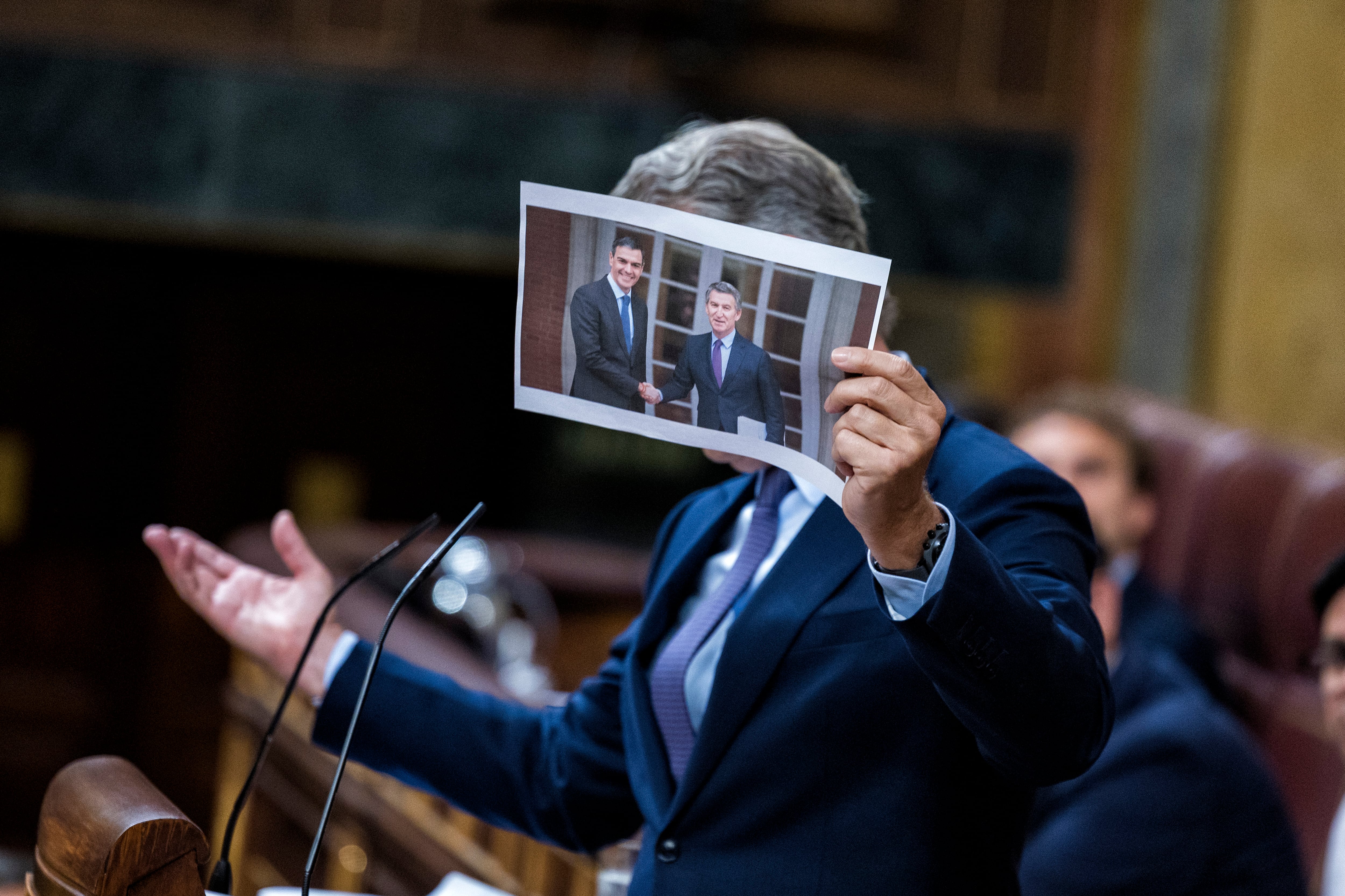 El líder del PP, Alberto Núñez Feijóo, con una imagen de él junto a Pedro Sánchez en el Palacio de la Moncloa.