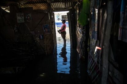 Una mujer, a la puerta de su casa inundada en el asentamiento "El Indio" en las afueras de Piura, Perú.