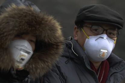 Muchos pequineses salen a la calle con m&aacute;scaras.