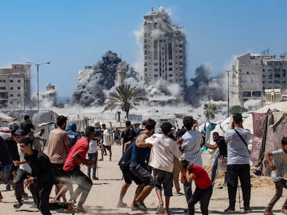 Un grupo de palestinos presencia el ataque israelí contra la Torre Mushtaha este viernes en Gaza.