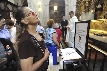 Una mujer reza por la salud del cura en la catedral.