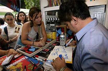 Pedro Almodóvar dedica un ejemplar a una admiradora en la caseta de la librería Ocho y medio.